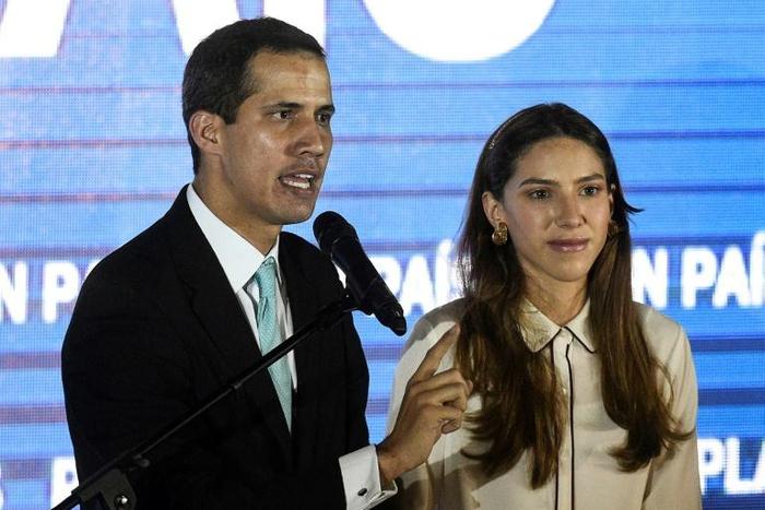 Venezuela's opposition leader Juan Guaido (L) accuses -- with his wife Fabiana Rosales by his side -- the country's security forces of trying to intimidate her