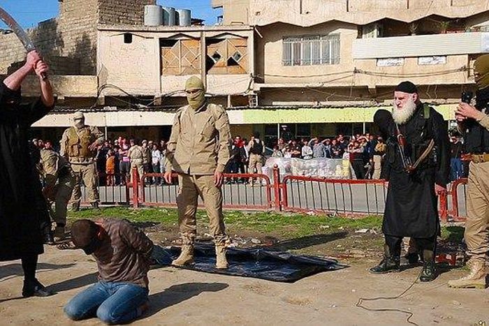The executioner stands with the sword poised above the man's head as a large crowd gathers to watch