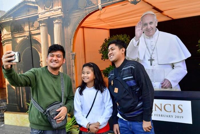 Worshippers pose for a selfie with a cutout image of Pope Francis at St Mary's Catholic Church in Dubai on January 30, 2019, days ahead of his visit to the United Arab Emirates