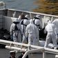 Italian coastguard and Armed Forces of Malta personnel in protective clothing stand near the bodies of dead immigrants on the ship Bruno Gregoretti in Senglea in Valletta's Grand Harbour, April 20, 2015. REUTERS/Darrin Zammit Lupi