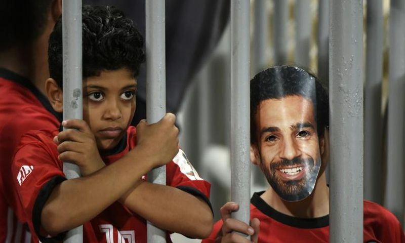 A fan wearing a mask of Egyptian football star Mohamed Salah poses for a photograph prior to the 2019 Africa Cup of Nations qualifier between Egypt and Niger on September 8, 2018 at the Borg el-Arab stadium near the Mediterranean city of Alexandria
