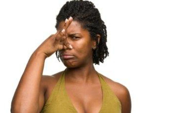 African woman covering her nose.