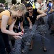 People cut a net that symbolises a fence, during a demonstration against a fence being built at the Hungarian-Serbian border, in Budapest, Hungary, July 14, 2015. REUTERS/Bernadett Szabo