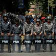 Venezuelan police stand guard near a hospital during a protest against the government of President Nicolas Maduro