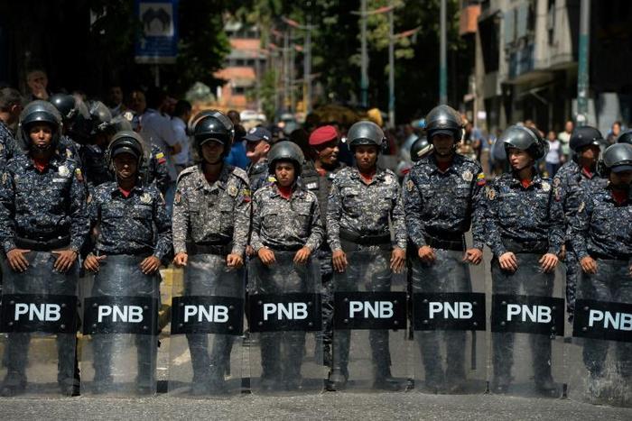 Venezuelan police stand guard near a hospital during a protest against the government of President Nicolas Maduro