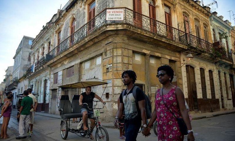 People walk past a building for sale in Havana, Cuba, as US Secretary of State Mike Pompeo warned foreign businesses to steer clear of formerly private properties seized by the island nation