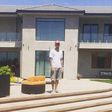 Chris Brown standing in front of his new home