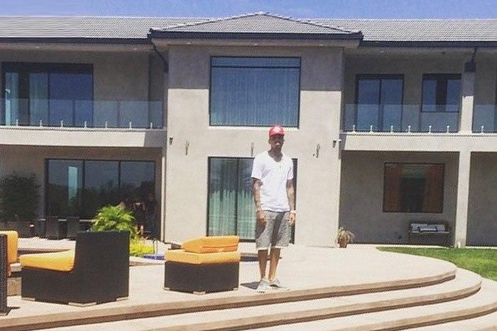 Chris Brown standing in front of his new home