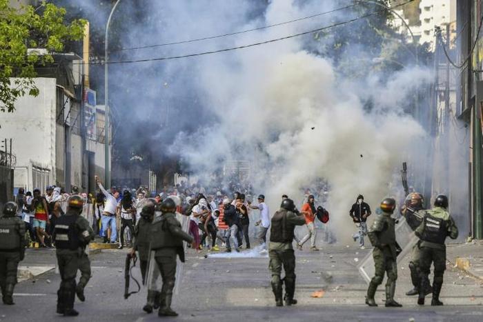 Riot police clash with opposition demonstrators in Caracas