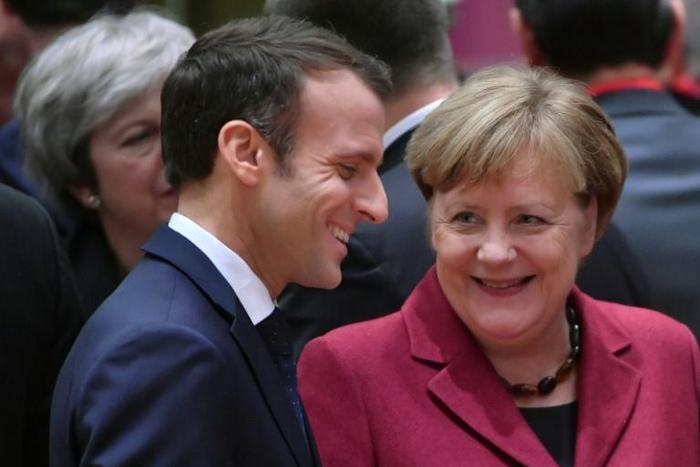 France's President Emmanuel Macron (L) talks with Germany's Chancellor Angela Merkel want to strengthen ties betweeen their two countries