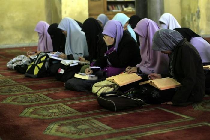 Students read during an Islamic course at Al-Azhar mosque in the old city of Cairo on December 4, 2011