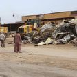 Men watch as bulldozers remove debris in front of a damaged building after a suicide car bomber blew himself up at a checkpoint in Dafniya outside Mistrata, Libya May 31, 2015. REUTERS/Stringer