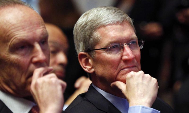 Apple CEO Tim Cook listening to a Barack Obama speech