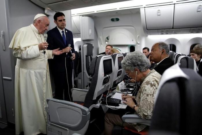 Pope Francis, flanked by Vatican spokesman Alessandro Gisotti (right) anwers journalists questions in the plane following the take off from Panama City on January 27, 2019 after participating in World Youth Day