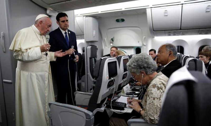 Pope Francis, flanked by Vatican spokesman Alessandro Gisotti (right) anwers journalists questions in the plane following the take off from Panama City on January 27, 2019 after participating in World Youth Day