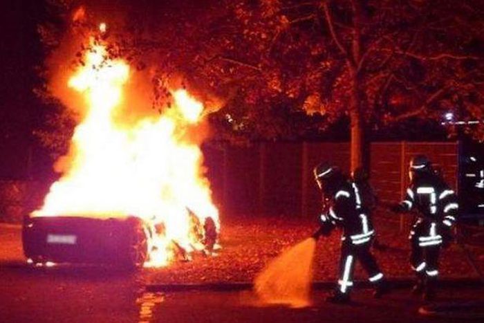 Fire fighters trying to put out the fire engulfing the Ferrari