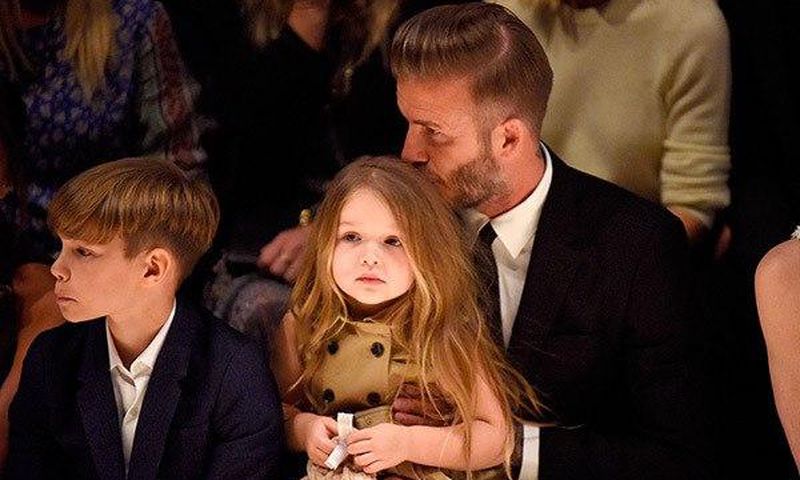 David Beckham kisses her daughter; Harper's hair during the show