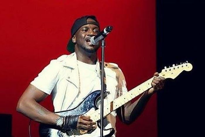 Peter Okoye playing the guitar on stage