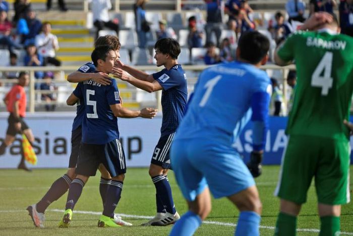 Yuya Osako is congratulated by Japanese teammates Yuto Nagatomo and Takumi Minamino after scoring in Wednesday's 3-2 win over Turkmenistan at the Asian Cup