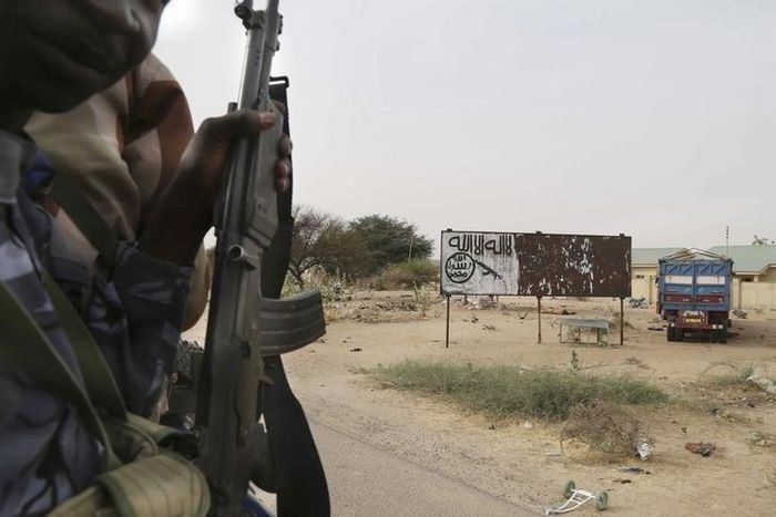 Chadian soldiers drive past a signpost painted by Boko Haram in the recently retaken town of Damasak, Nigeria, March 18, 2015.   REUTERS/Emmanuel Braun