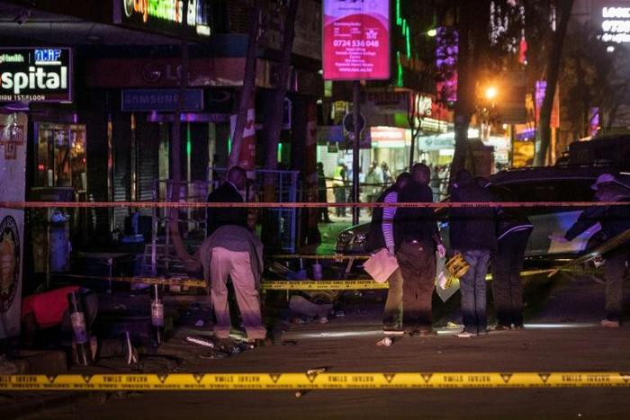 Criminal investigators officers collect evidence at the scene of a blast in the center of Nairobi that wounded at least two people