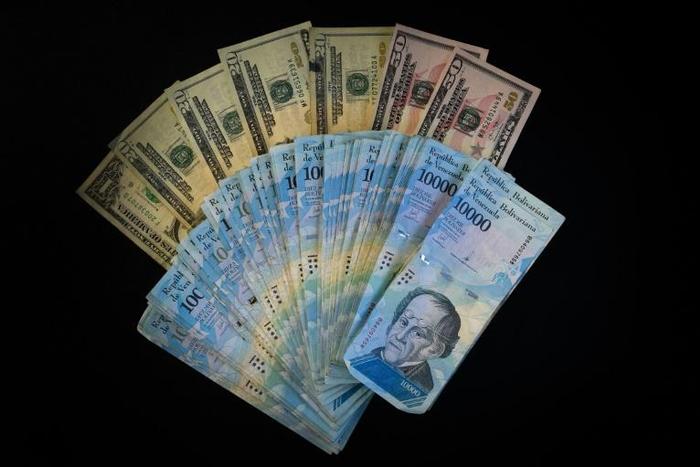The US is sanctioning seven Venezuelans for allegedly plundering billions of dollars via black-market currency exchanges -- dollars and Venezuela bolivars are seen here
