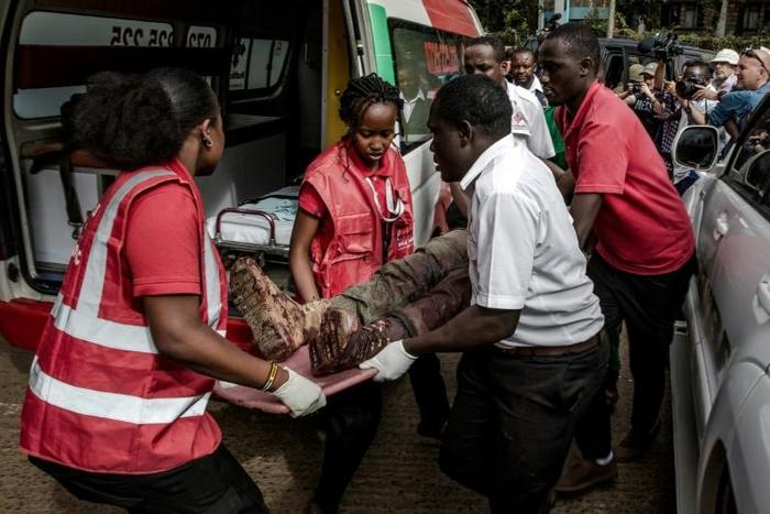 An injured member of the security forces is evacuated from the scene