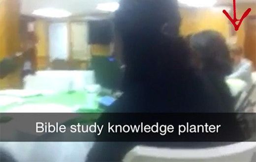 A screenshot from the video showing the killer, Dylann Roof at the far end.