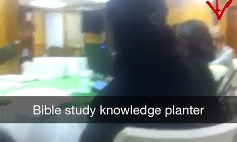 A screenshot from the video showing the killer, Dylann Roof at the far end.