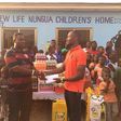 David Accam representing the items to the manager of the children's home