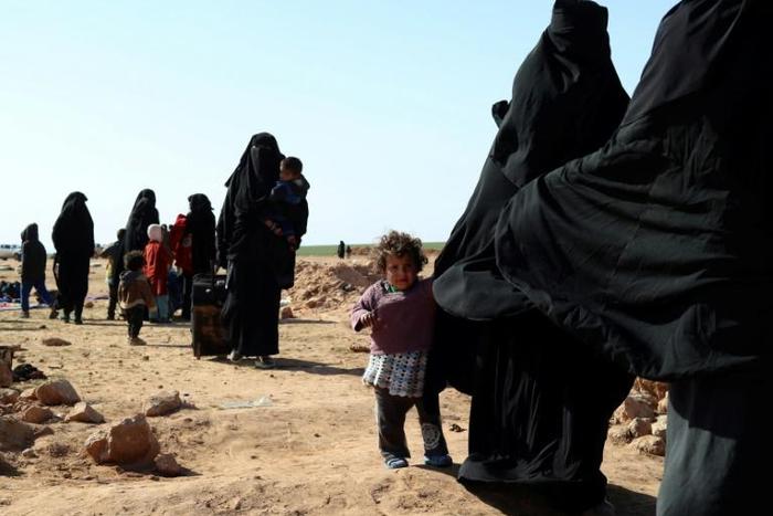 Civilians fleeing from fighting between Syrian Democratic Forces (SDF) and Islamic State (IS) jihadists in the frontline village of Baghuz, await to be screened and registered by the SDF in eastern Deir Ezzor province on January 31, 2019