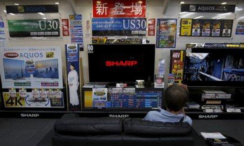 A man sitting on a sofa looks at a Sharp Corp's Aquos TV at an electronics retailer in Tokyo