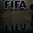 A man is silhouetted as he makes his way past the main entrance of FIFA headquarters, the Home of FIFA, in Zurich October 20, 2010. REUTERS/Christian Hartmann