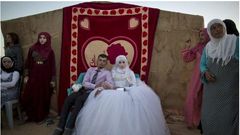 Ahmad Khalid and his bride, Fatheya Mohammed, both 21, sit in front of his family's tent during their wedding ceremony in an informal tent settlement on the outskirts of Mafraq, Jordan, near the Syrian border, on Aug. 7.