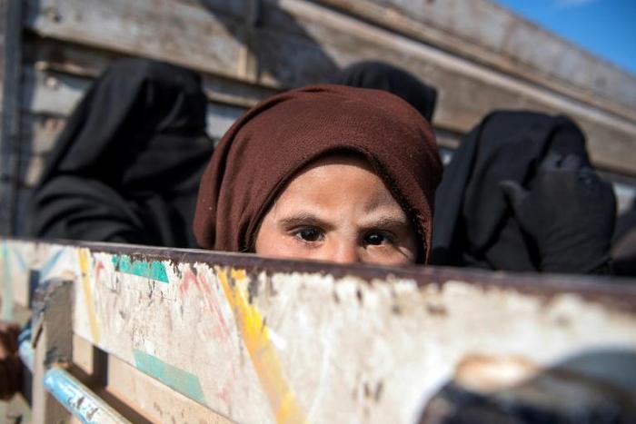 Women and children fleeing the Islamic State group's last holdout in eastern Syria pack into an open-back truck on February 11, 2019, for the long journey across the desert to a camp for the displaced