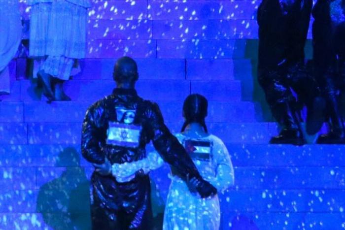 Two of Madonna's dancers are seen side-by-side with Israeli and Palestinian flags on their backs during her performance at Eurovision