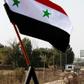 The Syrian national flag flies in front the Quneitra border crossing into the Israeli annexed-Golan Heights