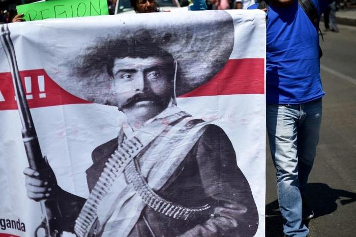 Teachers carrying a banner depicting Mexican revolutionary leader Emiliano Zapata shout slogans during a protest in Mexico City