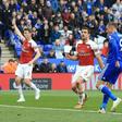 Jamie Vardy (R) slots the ball past Arsenal goalkeeper Bernd Leno (L) to complete a 3-0 win for Leicester