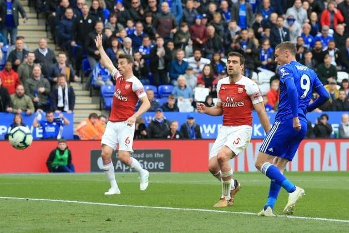 Jamie Vardy (R) slots the ball past Arsenal goalkeeper Bernd Leno (L) to complete a 3-0 win for Leicester