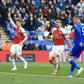 Jamie Vardy (R) slots the ball past Arsenal goalkeeper Bernd Leno (L) to complete a 3-0 win for Leicester