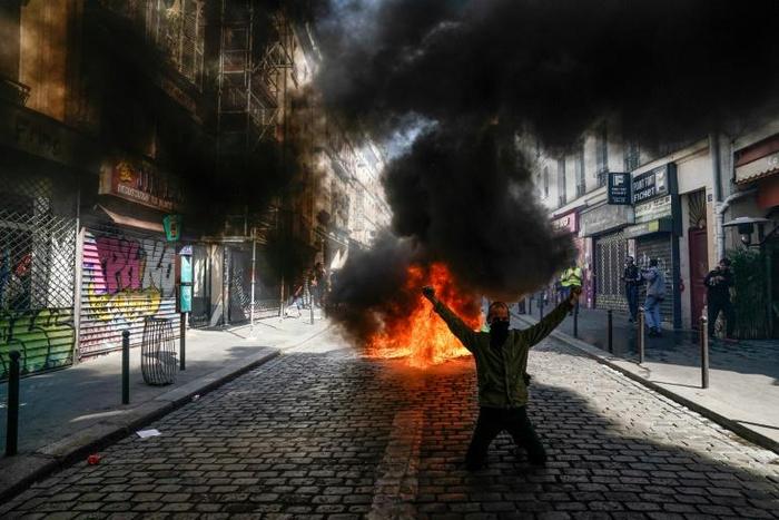 A protester in front of a fire during an anti-government demonstration in Paris
