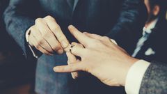Gay Men Exchanging Rings At Wedding Ceremony