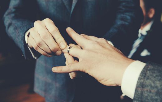 Gay Men Exchanging Rings At Wedding Ceremony