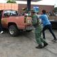 People push a vehicle up to the pump to fill up on gas at a station in Acarigua in Venezuela, which has started rationing fuel