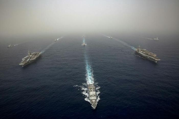 The US aircraft carrier USS Abraham Lincoln, on the left, sails in formation in the Mediterranean alongside British, French, Spanish and other US warships last month in an image released by the US Navy