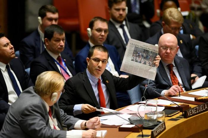 Venezuelan Foreign Minister Jorge Arreaza (C) shows a newspaper as he speaks to a United Nations Security Council meeting on the situation in Venezuela on January 26, 2019