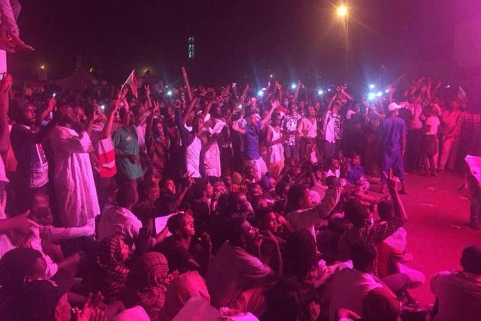 Nighttime protesters chant slogans against Sudan's government in front of the army headquarters