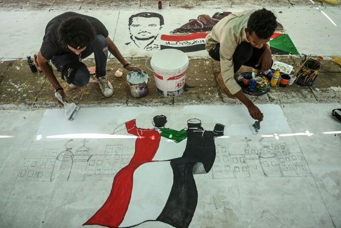 Sudanese protesters paint a mural during a sit-in outside the army headquarters in the capital Khartoum on April 28, 2019