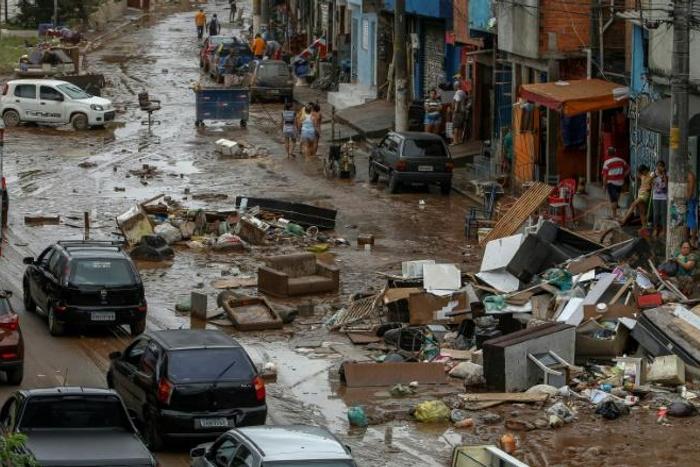 The unusually heavy rain that struck the Rio de Janeiro region triggered flash flooding that turned some streets into raging rivers, gushing through ground-level homes and businesses and weakening structures